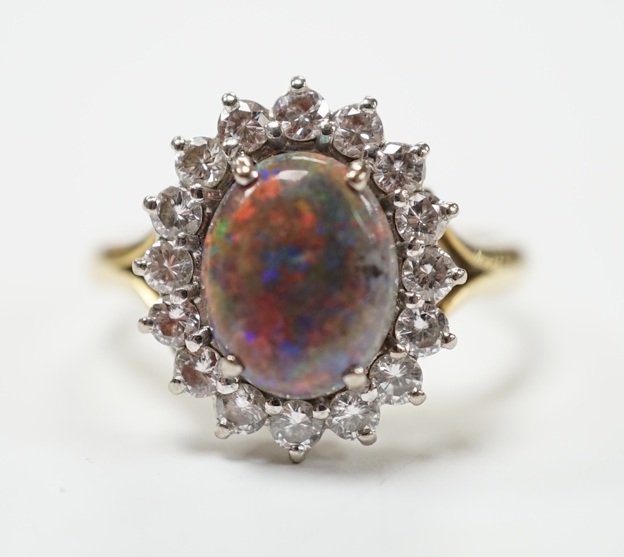 An 18ct, black opal and diamond set oval cluster ring, size P/Q, gross weight 5.4 grams. Fair condition.